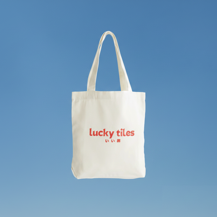 White tote bag with 'lucky tiles' text on a blue background